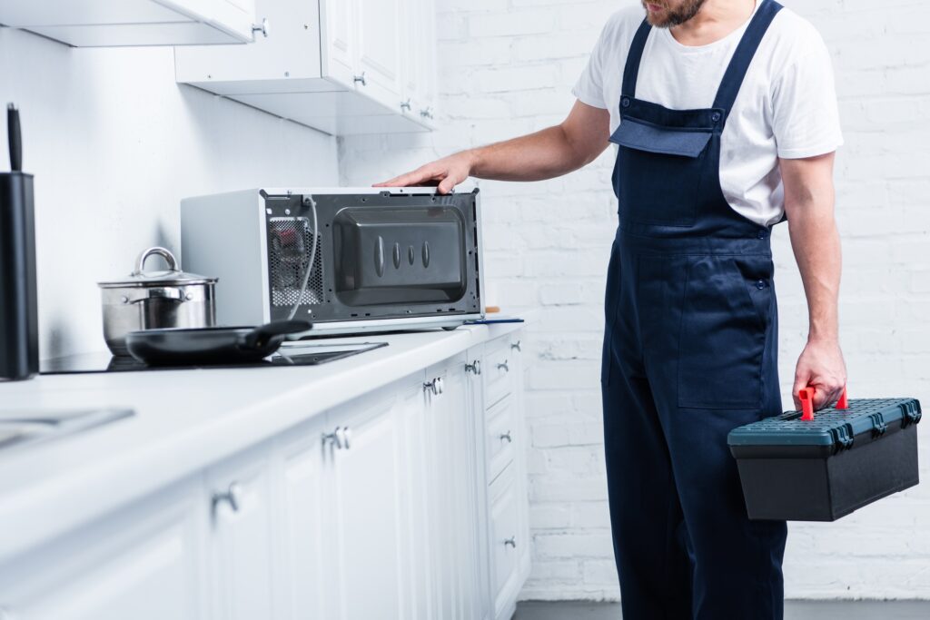 Technician holding a toolbox at a kitchen counter